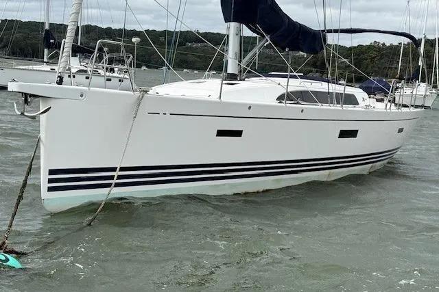  Yacht Photos Pics 2016 X-Yachts XP-44 sailboat anchored in a calm bay with lush green shoreline.