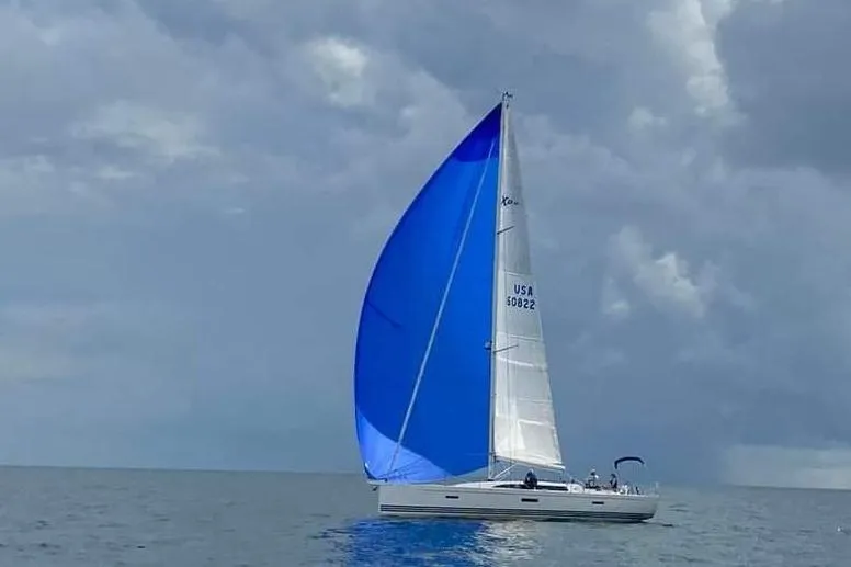  Yacht Photos Pics 2016 X-Yachts XP-44 sailing with blue spinnaker under cloudy skies.