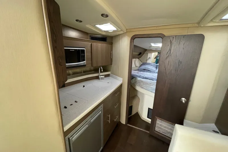  Yacht Photos Pics 2019 Rinker 370 EX interior with kitchenette and cozy sleeping area.