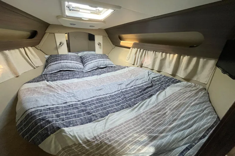  Yacht Photos Pics 2019 Rinker 370 EX cabin interior with cozy bed and striped bedding.