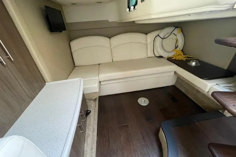  Yacht Photos Pics 2019 Rinker 370 EX cabin interior with white seating, TV, and life preserver.