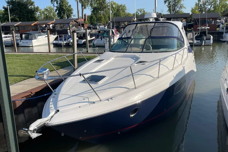  Yacht Photos Pics 2019 Rinker 370 EX boat docked in a marina, surrounded by other vessels.