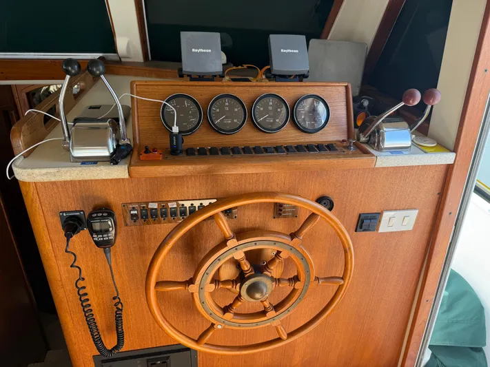 Real Therapy Yacht Photos Pics 2001 Mainship 390 Trawler helm with wooden wheel, gauges, and navigation equipment.