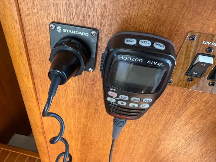 Real Therapy Yacht Photos Pics VHF radio and power outlet on 2001 Mainship 390 Trawler's wooden dashboard.