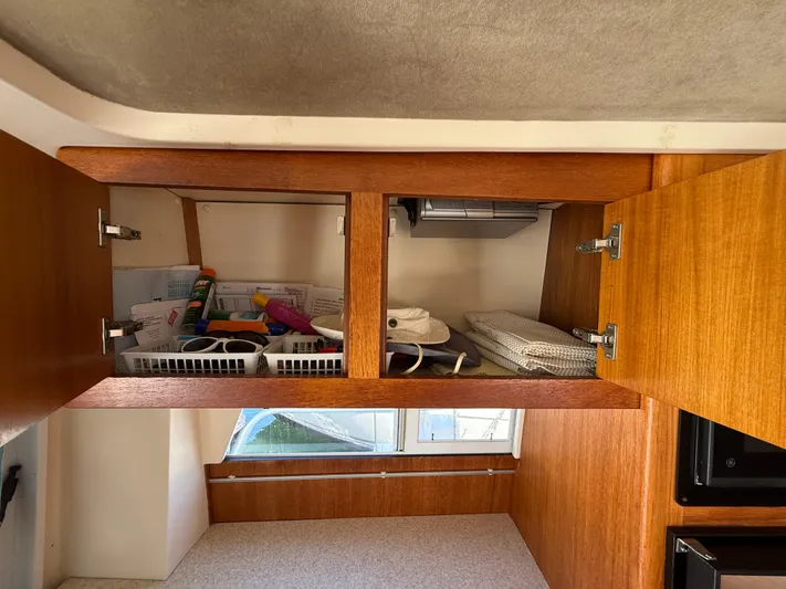 Real Therapy Yacht Photos Pics 2001 Mainship 390 Trawler interior cabinet with organized storage and accessories.