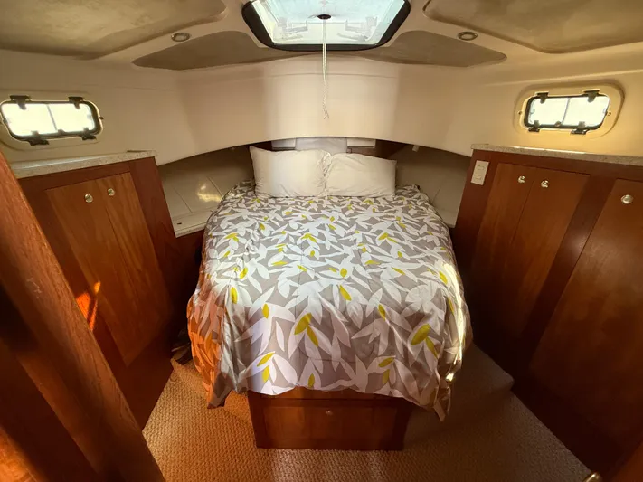 Real Therapy Yacht Photos Pics Cozy cabin interior of 2001 Mainship 390 Trawler with bed and wooden cabinets.