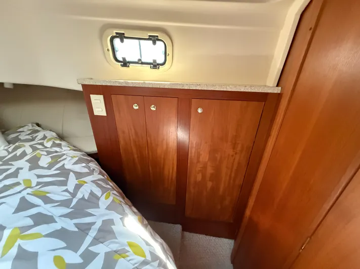 Real Therapy Yacht Photos Pics 2001 Mainship 390 Trawler cabin interior with wooden cabinetry and floral bedding.