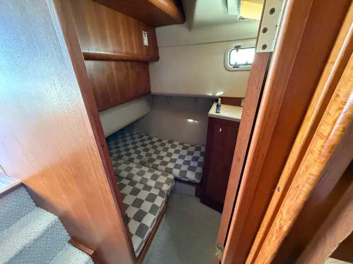 Real Therapy Yacht Photos Pics 2001 Mainship 390 Trawler cabin with checkered bedding and wooden interior.