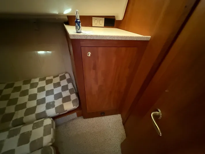 Real Therapy Yacht Photos Pics 2001 Mainship 390 Trawler cabin interior with checkered cushions and wooden cabinetry.