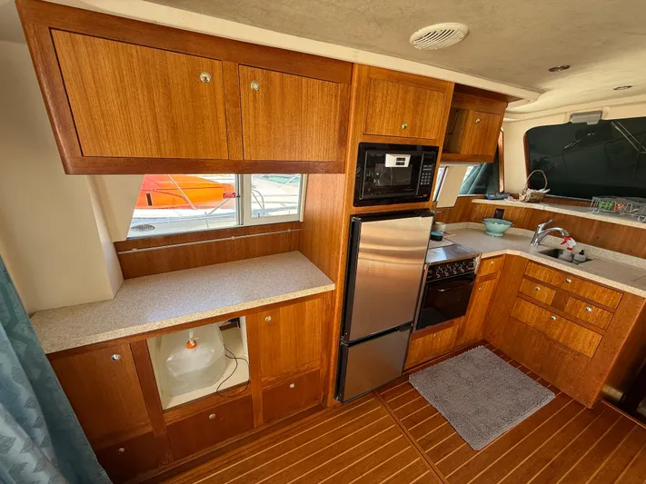 Real Therapy Yacht Photos Pics 2001 Mainship 390 Trawler kitchen with wood cabinets, stainless appliances, and countertop.