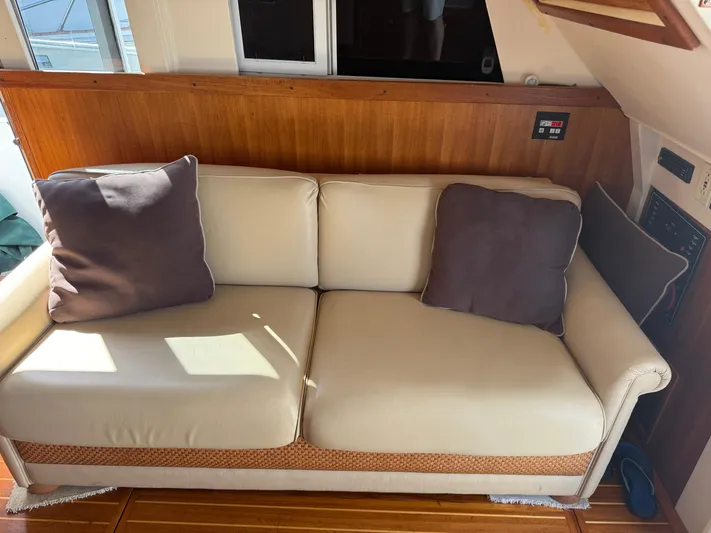 Real Therapy Yacht Photos Pics Cream sofa with brown cushions inside a 2001 Mainship 390 Trawler boat.