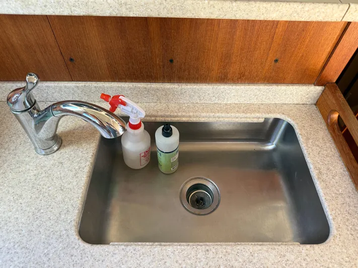 Real Therapy Yacht Photos Pics Stainless steel sink with faucet and cleaning supplies on Mainship 390 Trawler, 2001 model.