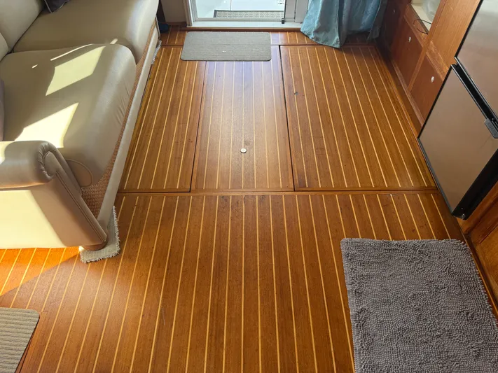 Real Therapy Yacht Photos Pics Interior of 2001 Mainship 390 Trawler with wooden flooring and beige sofa.