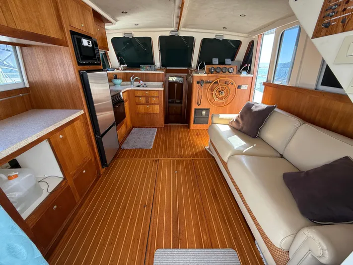 Real Therapy Yacht Photos Pics 2001 Mainship 390 Trawler interior with wood finish, kitchen, and seating area.