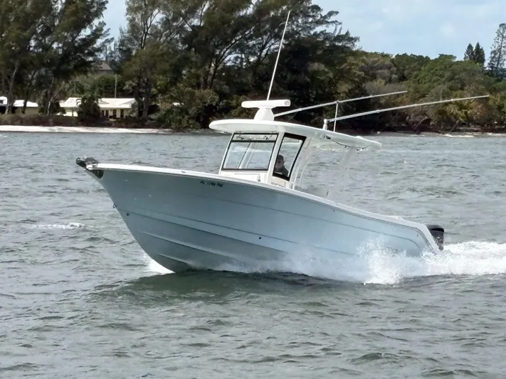  Yacht Photos Pics 2018 Robalo R302 Center Console boat cruising on a scenic waterway.