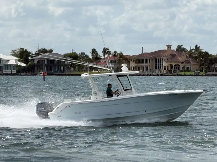  Yacht Photos Pics 2018 Robalo R302 Center Console boat cruising on a scenic waterway.