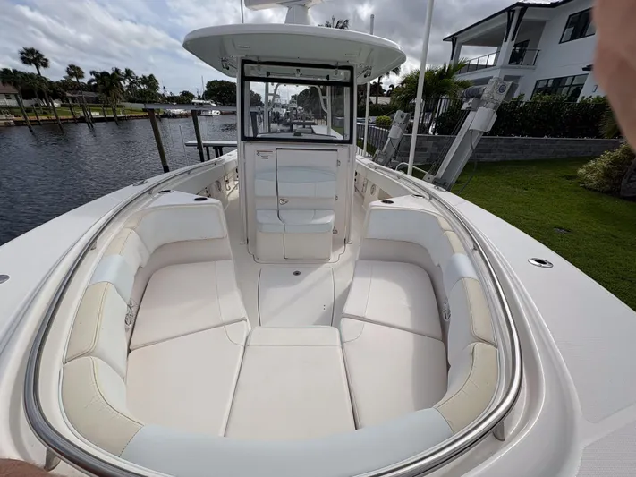  Yacht Photos Pics 2018 Robalo R302 Center Console boat with spacious seating, docked near waterfront homes.
