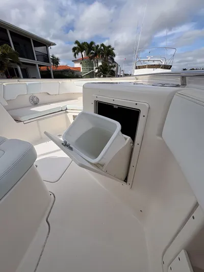  Yacht Photos Pics 2018 Robalo R302 Center Console boat with open storage compartment, docked near waterfront homes.