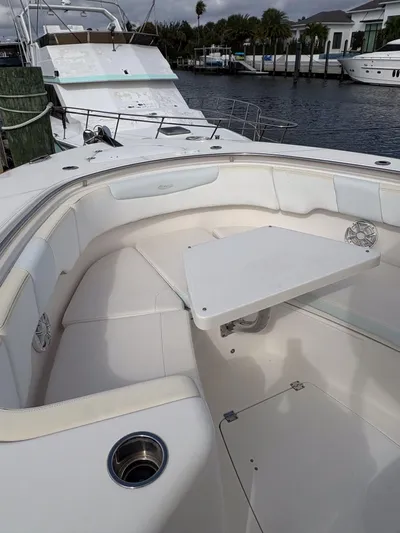 Yacht Photos Pics 2018 Robalo R302 Center Console boat interior with seating and table, docked by waterfront homes.