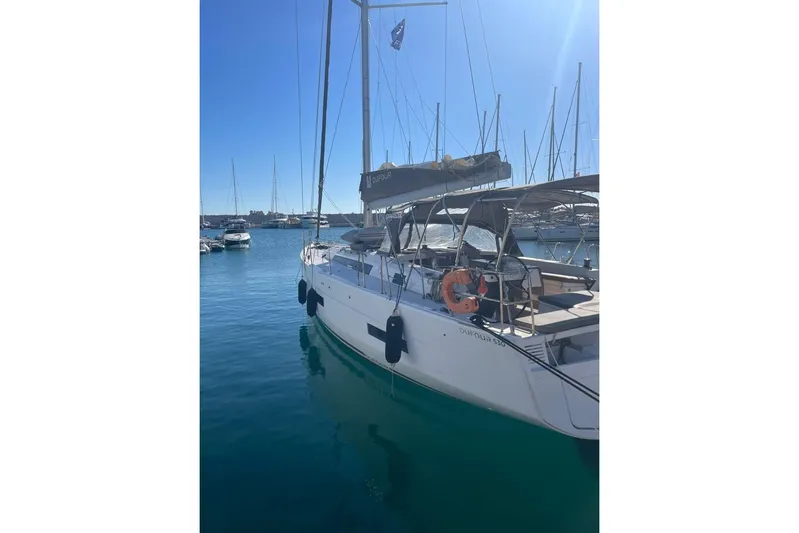  Yacht Photos Pics 2022 Dufour 530 yacht docked in a sunny marina, showcasing sleek design and modern features.