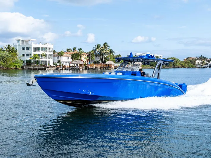  Yacht Photos Pics 2020 Midnight Express Open boat cruising on a sunny day near waterfront homes.