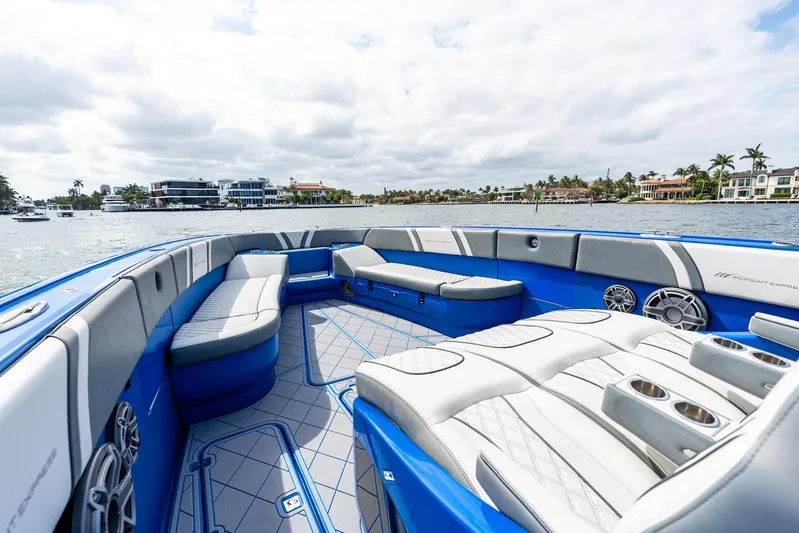  Yacht Photos Pics Luxurious 2020 Midnight Express Open boat interior with blue and white seating, on a scenic waterfront.