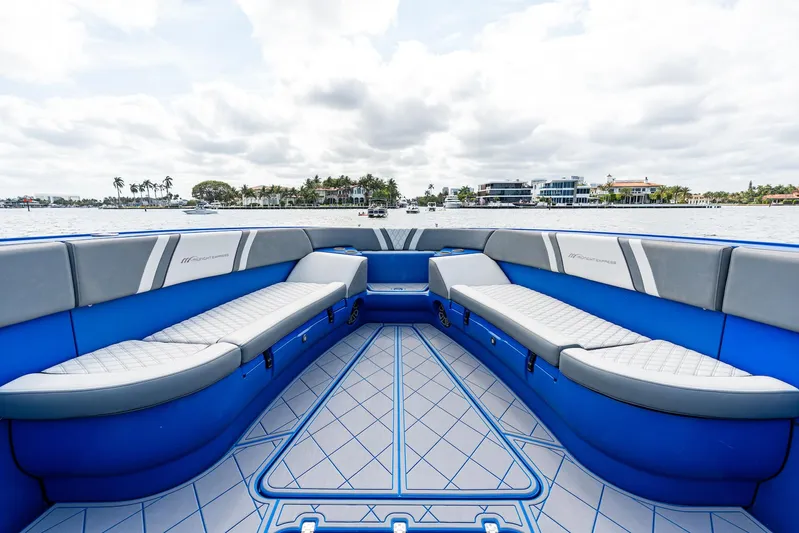  Yacht Photos Pics 2020 Midnight Express Open boat interior with blue and gray seating, overlooking a scenic waterfront.