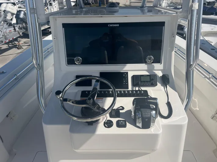  Yacht Photos Pics Control panel of a 2019 Contender 32 ST boat with steering wheel and navigation equipment.
