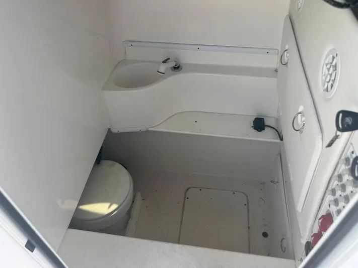  Yacht Photos Pics Interior of 2019 Contender 32 ST boat showing compact bathroom with toilet and sink.