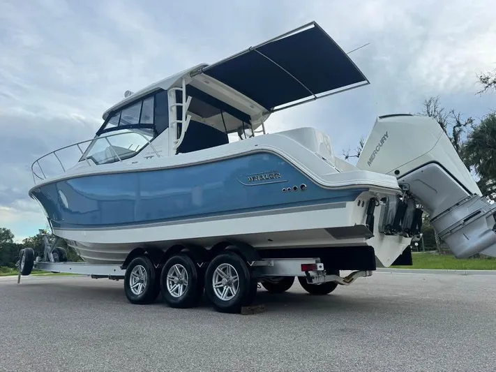  Yacht Photos Pics 2023 Boston Whaler 325 Conquest boat on trailer, featuring sleek design and dual Mercury engines.