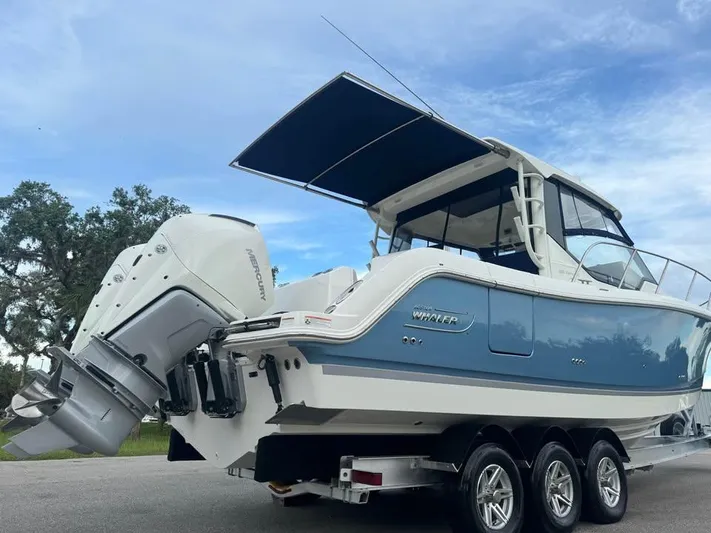 Yacht Photos Pics 2023 Boston Whaler 325 Conquest boat on trailer, featuring dual Mercury engines.