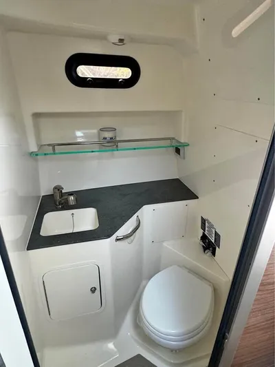  Yacht Photos Pics 2023 Boston Whaler 325 Conquest bathroom with sink, toilet, and shelf.