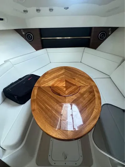  Yacht Photos Pics 2023 Boston Whaler 325 Conquest cabin with wooden table and white seating.