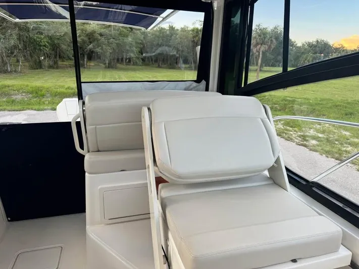  Yacht Photos Pics 2023 Boston Whaler 325 Conquest interior with white seating and scenic outdoor view.
