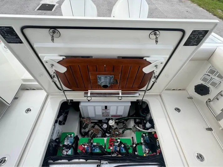  Yacht Photos Pics 2023 Boston Whaler 325 Conquest engine compartment with open hatch, showcasing batteries and equipment.