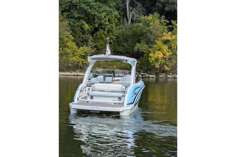 310 Bow Rider Yacht Photos Pics 2025 Formula 310 Bowrider I/O cruising on a serene lake with lush greenery.