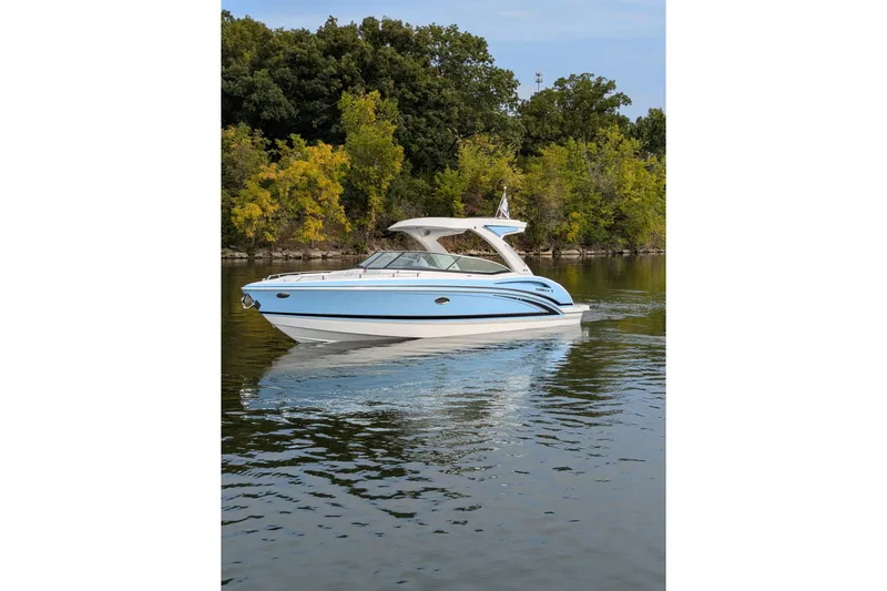 310 Bow Rider Yacht Photos Pics 2025 Formula 310 Bowrider I/O boat cruising on a serene lake with lush greenery.