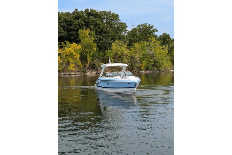 310 Bow Rider Yacht Photos Pics 2025 Formula 310 Bowrider I/O cruising on a serene lake with lush green trees.