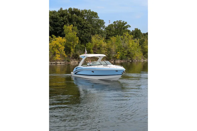 310 Bow Rider Yacht Photos Pics 2025 Formula 310 Bowrider I/O cruising on a serene lake with lush greenery.