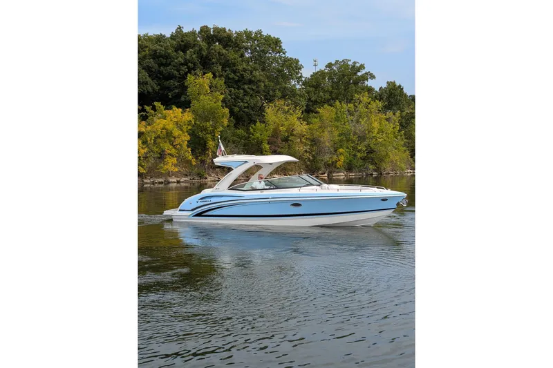 310 Bow Rider Yacht Photos Pics 2025 Formula 310 Bowrider I/O cruising on a calm lake with lush green trees.