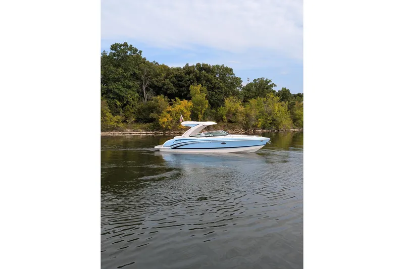 310 Bow Rider Yacht Photos Pics 2025 Formula 310 Bowrider I/O cruising on a serene lake with lush greenery.