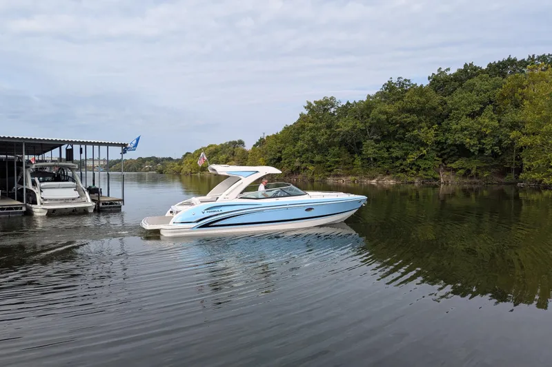 310 Bow Rider Yacht Photos Pics 2025 Formula 310 Bowrider I/O cruising on a serene lake near a dock.