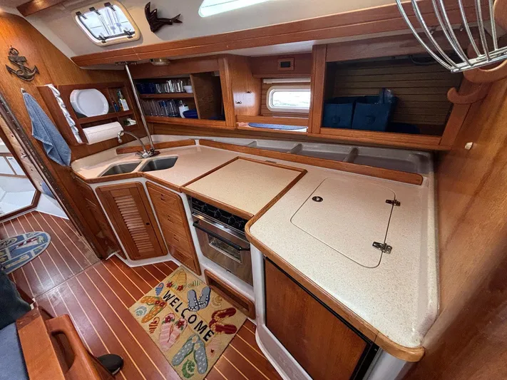 Unbridled Yacht Photos Pics Spacious 1996 Catalina 42 yacht kitchen with wooden cabinetry and modern appliances.
