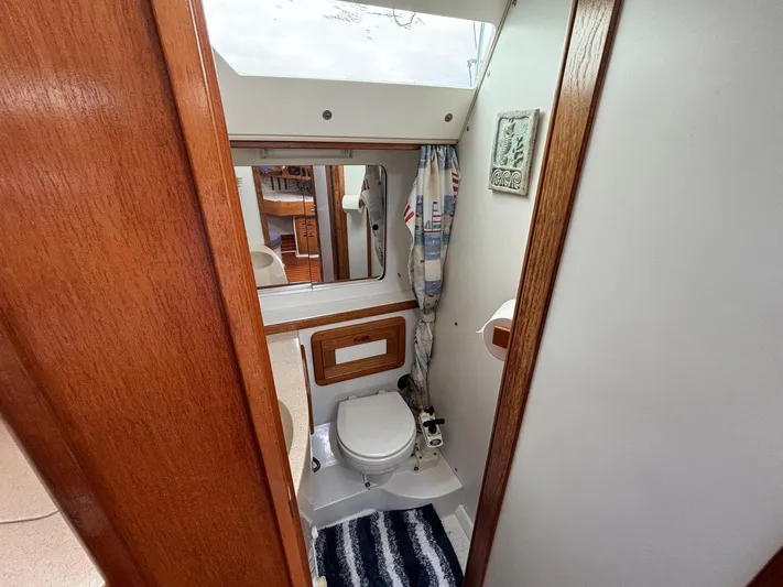 Unbridled Yacht Photos Pics 1996 Catalina 42 yacht bathroom with wooden accents and nautical decor.