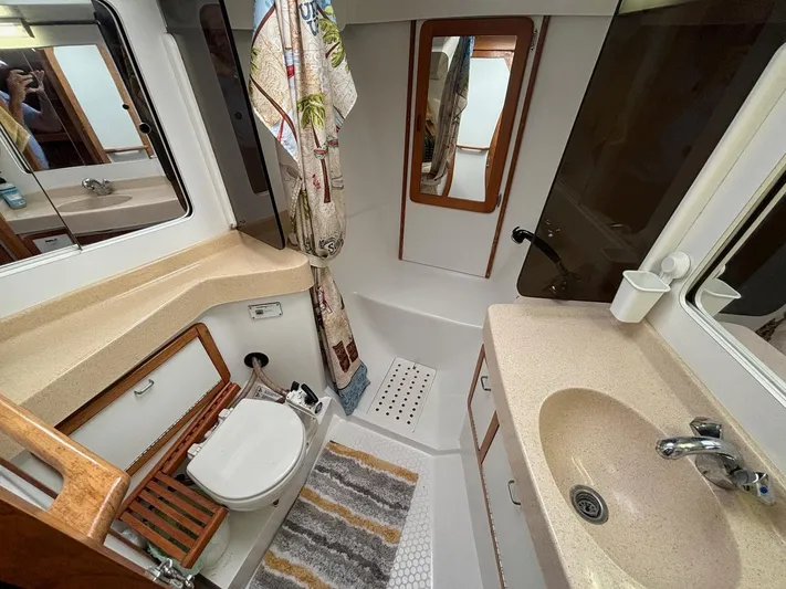 Unbridled Yacht Photos Pics Bathroom interior of a 1996 Catalina 42 yacht, featuring a shower, sink, and toilet.