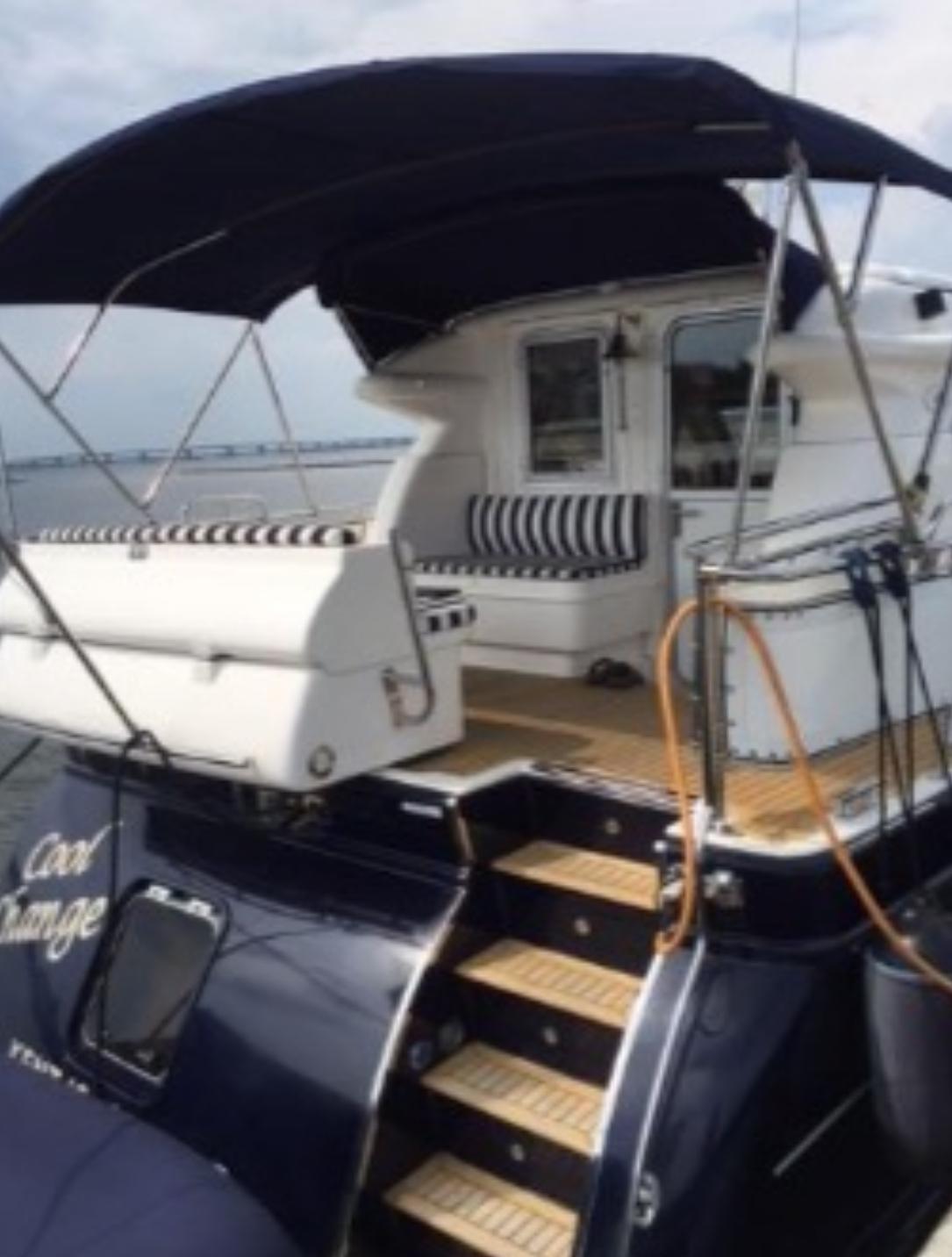 2007 Elling E3 yacht with striped seating and canopy, docked on calm water.