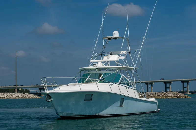Refit 2018 - Reel Deal Yacht Photos Pics 2012 SeaVee 43 Express boat on water, clear sky, bridge in background.