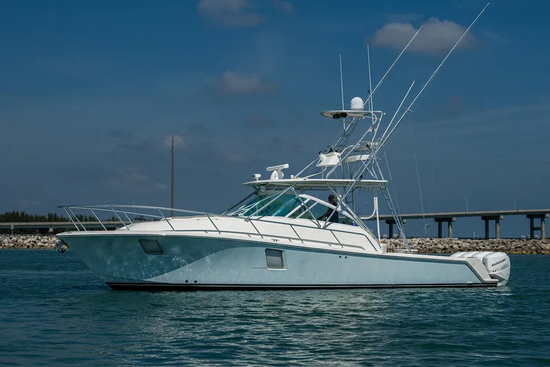 Refit 2018 - Reel Deal Yacht Photos Pics 2012 SeaVee 43 Express boat on water, clear sky, bridge in background.