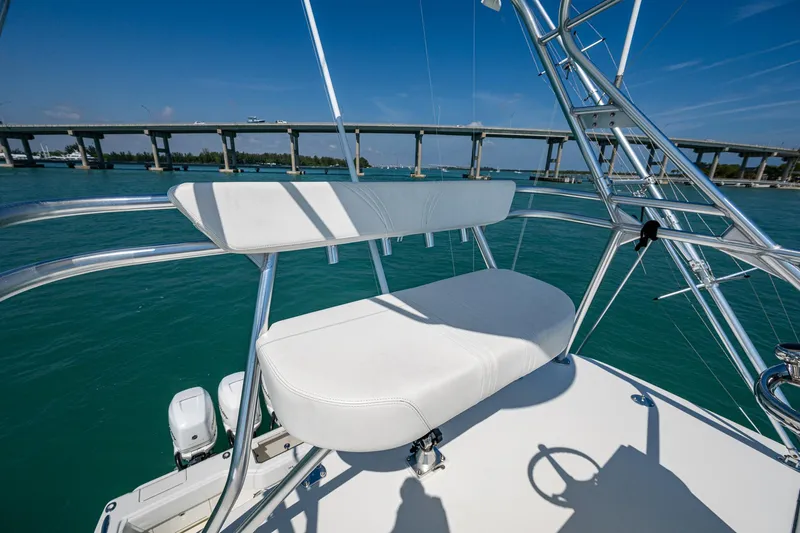 Refit 2018 - Reel Deal Yacht Photos Pics 2012 SeaVee 43 Express boat with white seating, overlooking a bridge and blue water.