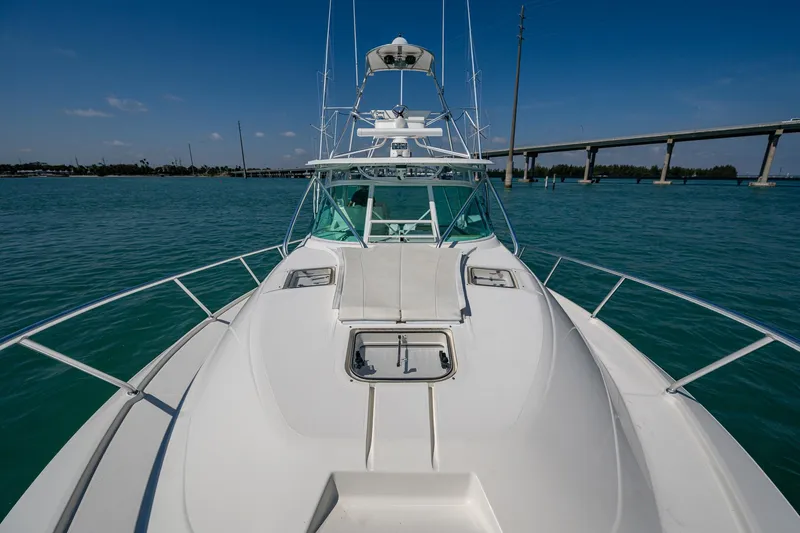 Refit 2018 - Reel Deal Yacht Photos Pics 2012 SeaVee 43 Express boat on calm water with clear sky and bridge in background.